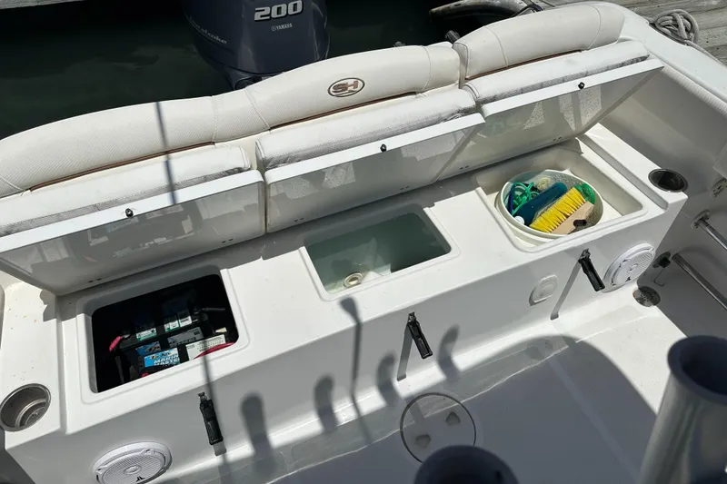 Slide: The Image of 2019 Sea Hunt Ultra 225 boat interior with storage compartments and Yamaha 200 engine. - 28