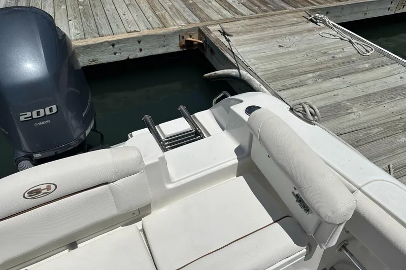 Slide: The Image of 2019 Sea Hunt Ultra 225 boat with Yamaha 200 engine docked at wooden pier. - 31