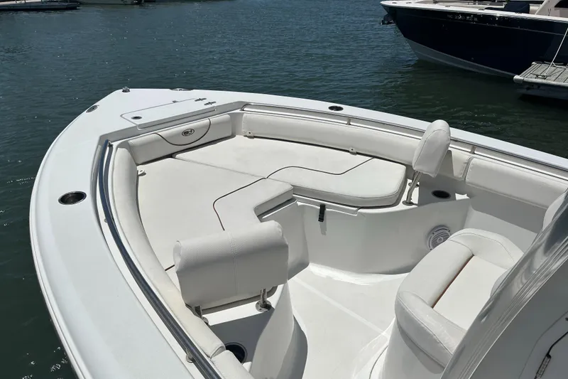Slide: The Image of 2019 Sea Hunt Ultra 225 boat with spacious seating, docked on calm water. - 5