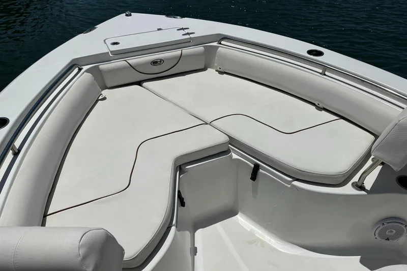 Slide: The Image of 2019 Sea Hunt Ultra 225 boat interior with cushioned seating and storage compartments. - 8