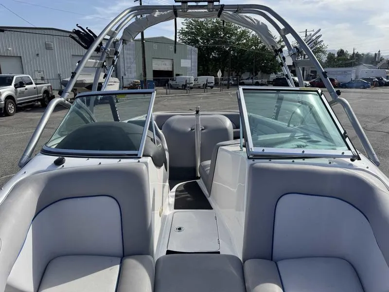 Slide: The Image of 2005 Centurion Elite boat interior with open windshield, parked in an industrial area. - 8