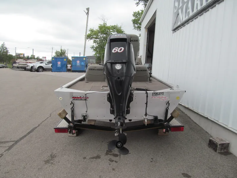 Slide: The Image of 1999 Tracker PRO TEAM 175 SE boat with 60 HP motor, parked outdoors. - 4