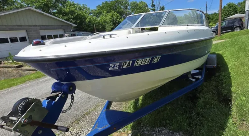 The Image of 2006 Bayliner 205 BR boat on trailer, parked outdoors on a sunny day. - 0
