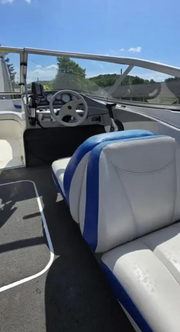 Slide: The Image of 2006 Bayliner 205 BR boat interior with blue and white seating, steering wheel, and dashboard. - 10