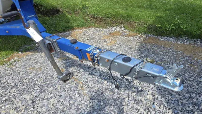 Slide: The Image of Trailer hitch of a 2006 Bayliner 205 BR on gravel, with green grass background. - 5