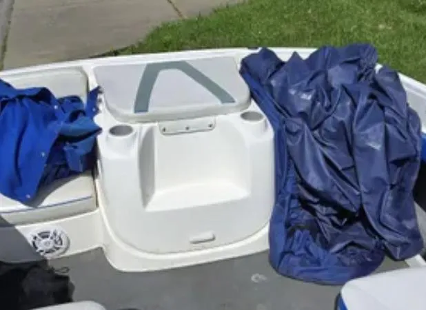 Slide: The Image of 2006 Bayliner 205 BR boat interior with blue covers and seating area. - 6