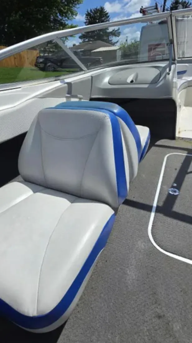 Slide: The Image of 2006 Bayliner 205 BR boat interior with blue and white seating, open deck view. - 9