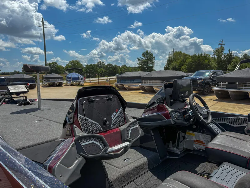 Slide: The Image of 2023 Skeeter FXR 21 Limited boat interior with steering wheel and seating under a blue sky. - 5