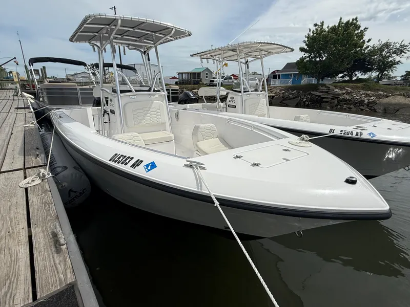 Slide: The Image of 2024 Aquasport 2200 Center Console boat docked, featuring sleek design and spacious seating. - 1
