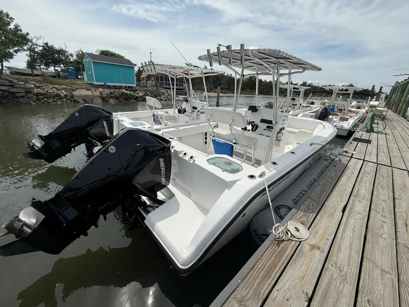 Slide: The Image of 2024 Aquasport 2200 Center Console boat docked with dual Mercury engines. - 4