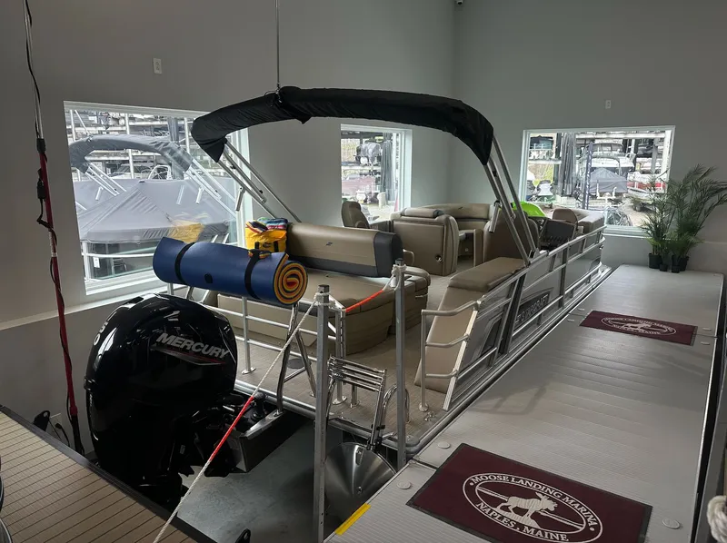 Slide: The Image of Starcraft EX 22 R 2026 pontoon boat in showroom with Mercury engine. - 3