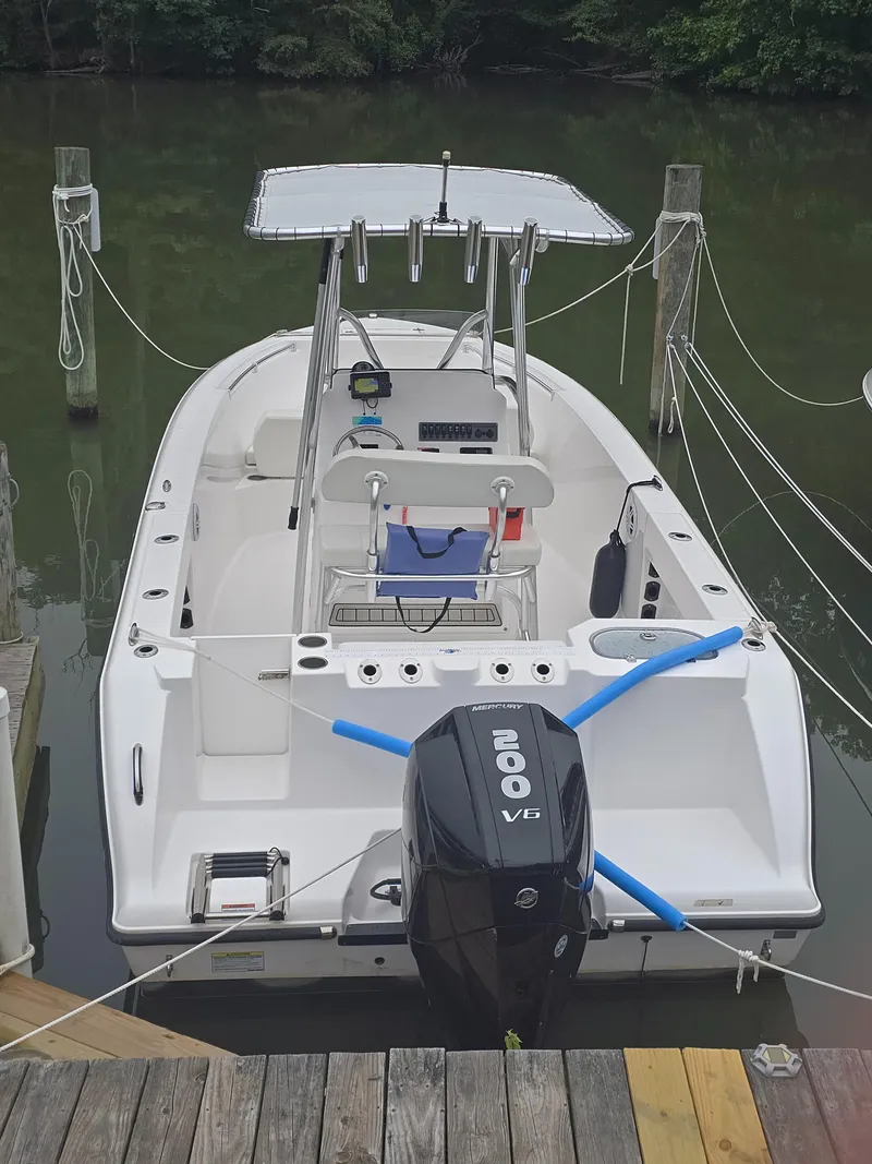 Slide: The Image of 2024 Aquasport 2200 Center Console boat docked with powerful 200 V6 engine. - 2