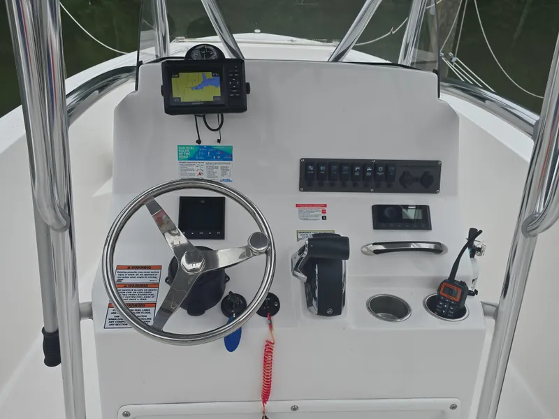 Slide: The Image of 2024 Aquasport 2200 Center Console dashboard with steering wheel, controls, and navigation equipment. - 3