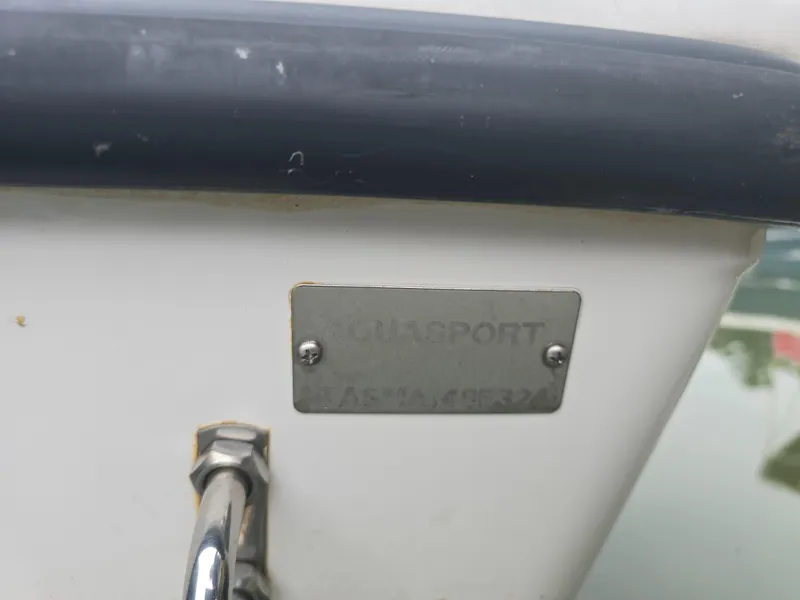 Slide: The Image of 2024 Aquasport 2200 Center Console nameplate on boat hull. - 6