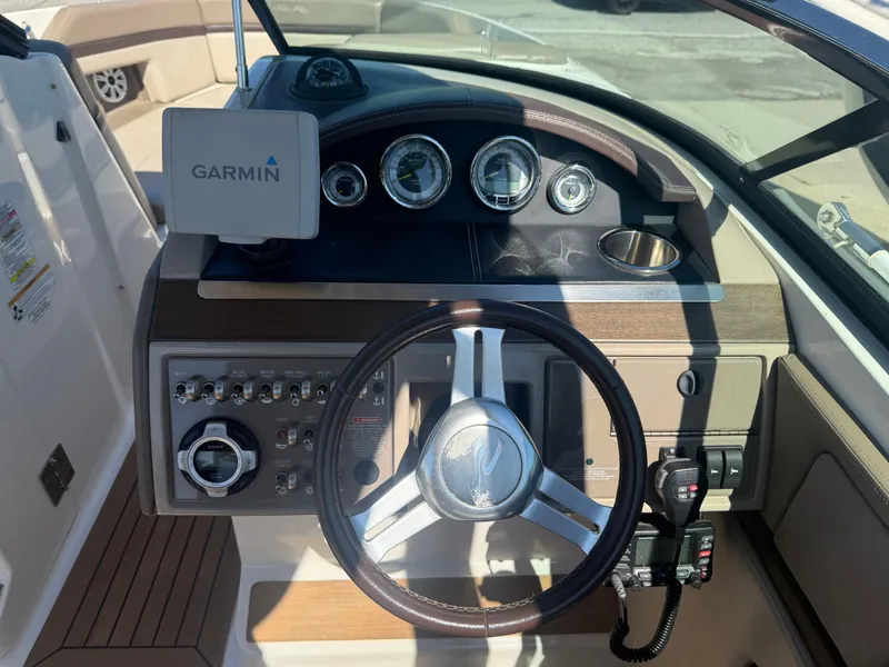 Slide: The Image of 2011 Sea Ray 250 SLX boat dashboard with Garmin navigation system and steering wheel. - 10