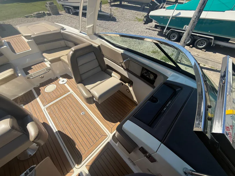 Slide: The Image of 2011 Sea Ray 250 SLX boat interior with beige seating and wood flooring. - 17