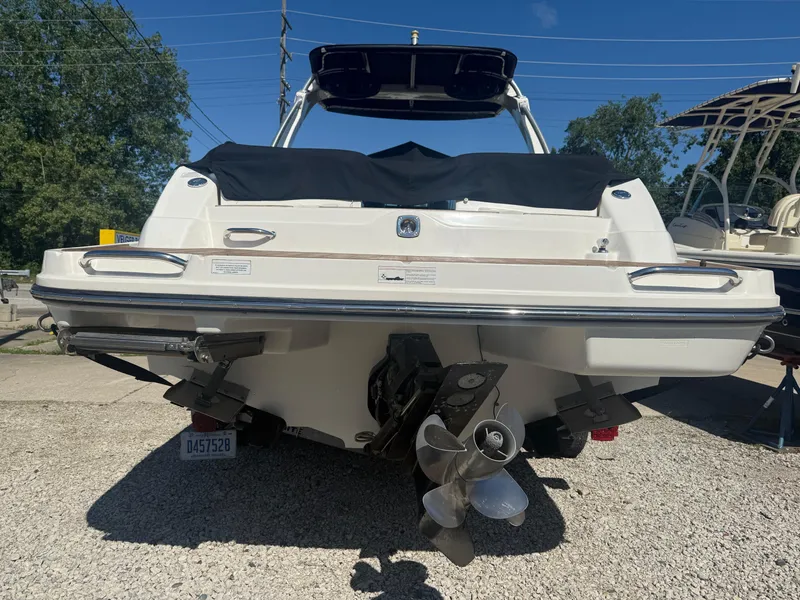 Slide: The Image of 2011 Sea Ray 250 SLX boat, rear view, on gravel lot under clear blue sky. - 32