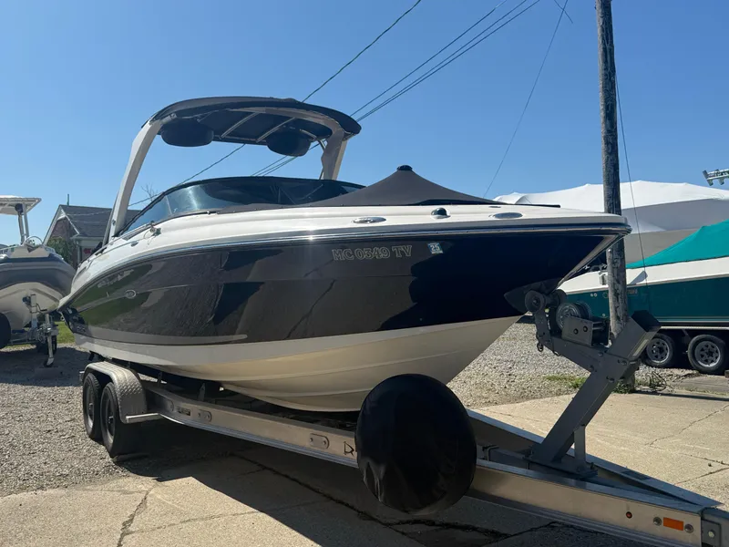 Slide: The Image of 2011 Sea Ray 250 SLX boat on trailer, parked outdoors under clear sky. - 34
