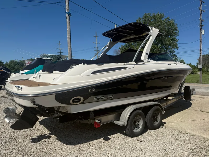 Slide: The Image of 2011 Sea Ray 250 SLX boat on trailer, parked outdoors under clear blue sky. - 37