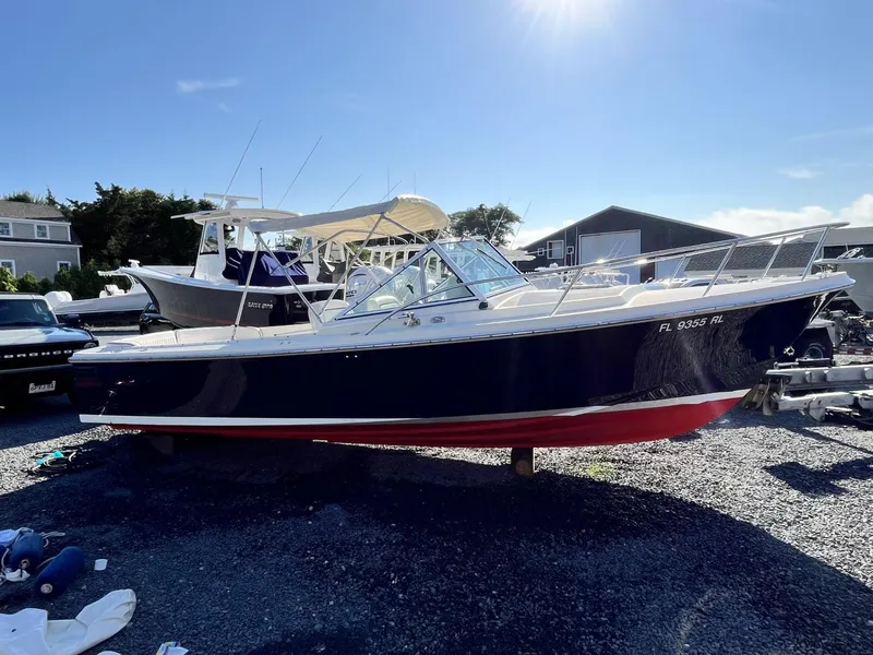 Slide: The Image of 2001 Limestone 24' Express Cruiser boat on gravel lot under clear sky. - 0