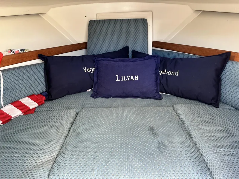 Slide: The Image of Interior of 2001 Limestone 24' Express Cruiser with blue cushions and personalized pillows. - 18