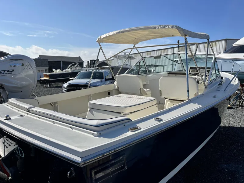 Slide: The Image of 2001 Limestone 24' Express Cruiser with canopy, docked outdoors under clear blue sky. - 4