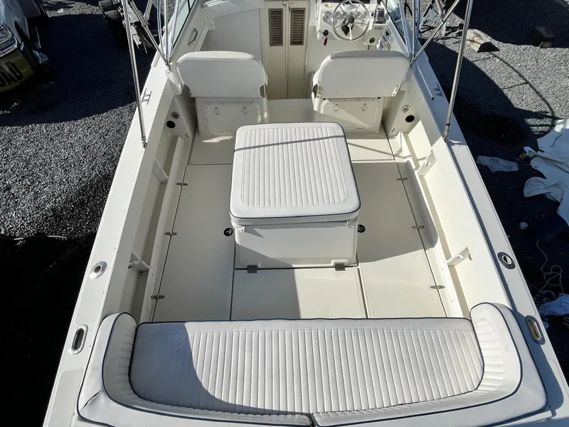 Slide: The Image of 2001 Limestone 24' Express Cruiser interior with white seating and steering console. - 5