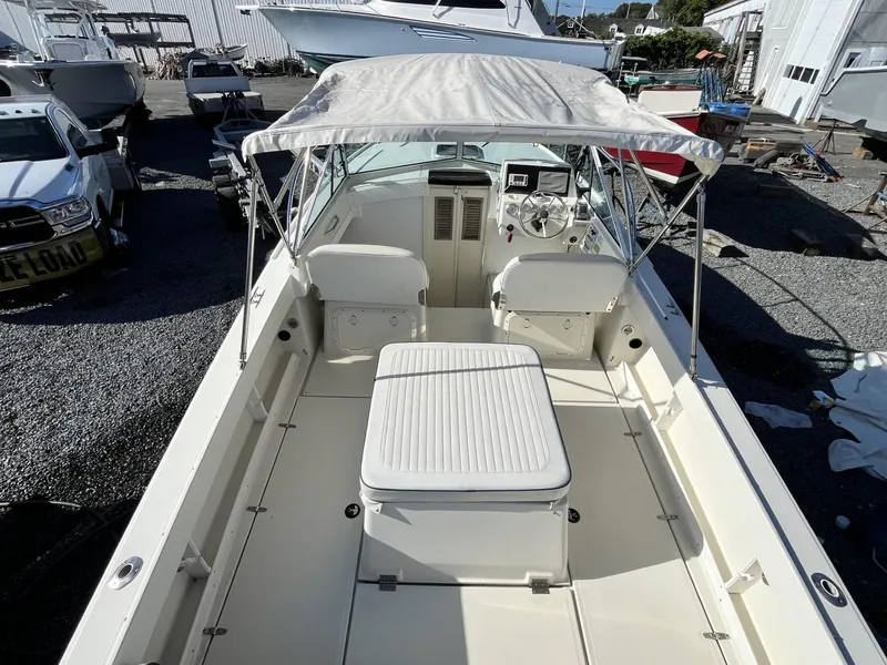 Slide: The Image of 2001 Limestone 24' Express Cruiser with canopy, parked in a marina. - 6