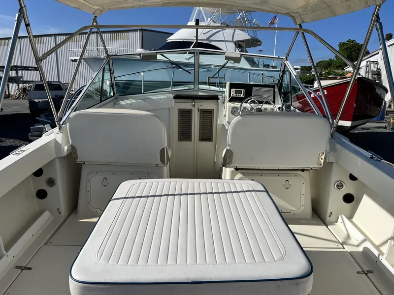 Slide: The Image of 2001 Limestone 24' Express Cruiser interior with seating and helm, docked at a marina. - 8