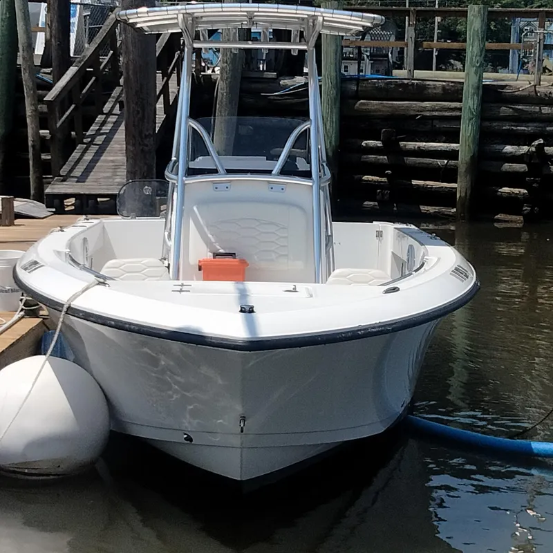 Slide: The Image of 2024 Aquasport 2200 Center Console boat docked at a marina. - 0