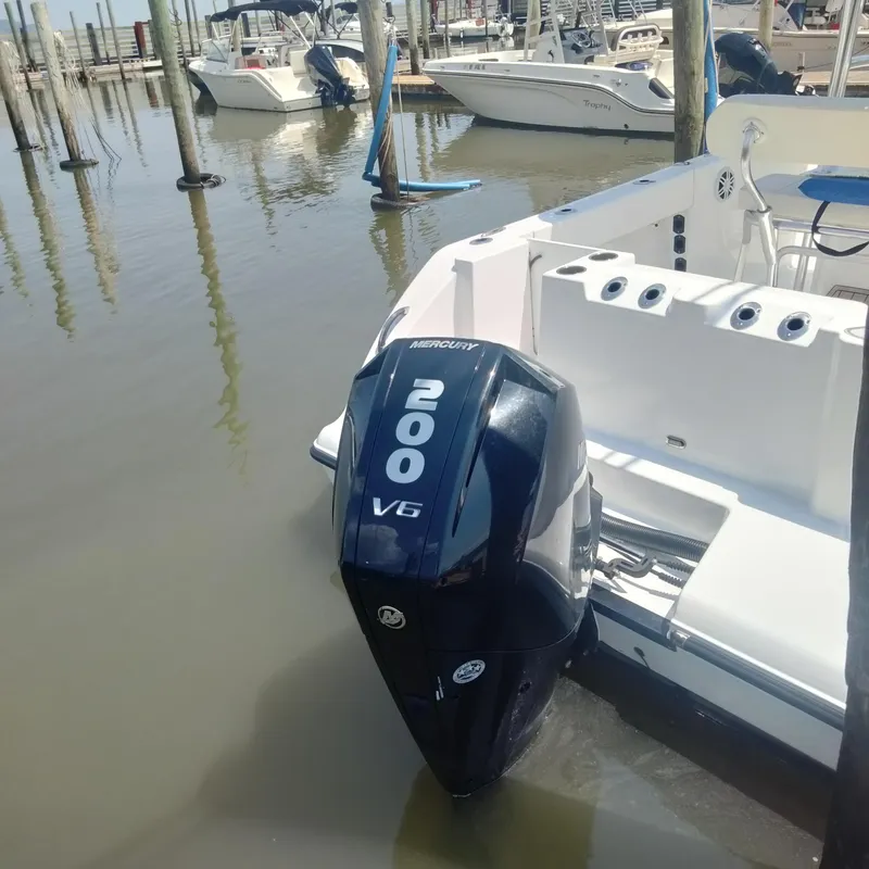 Slide: The Image of 2024 Aquasport 2200 Center Console with Mercury 200 V6 engine at dock. - 13