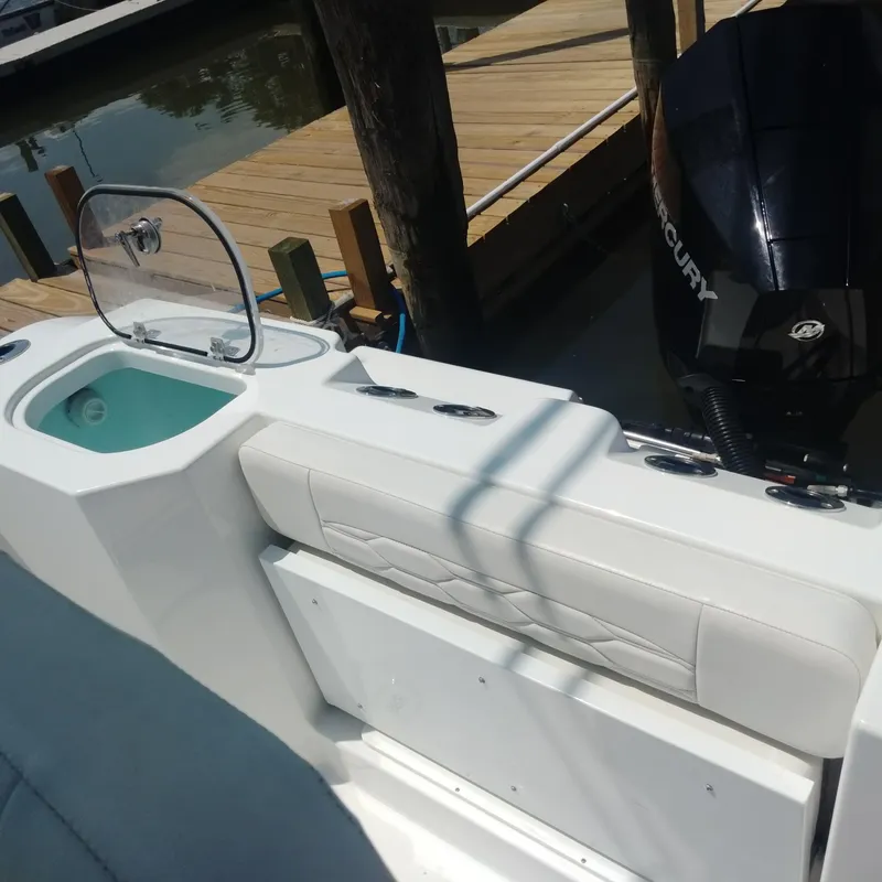 Slide: The Image of 2024 Aquasport 2200 Center Console boat with seating and engine, docked by wooden pier. - 4
