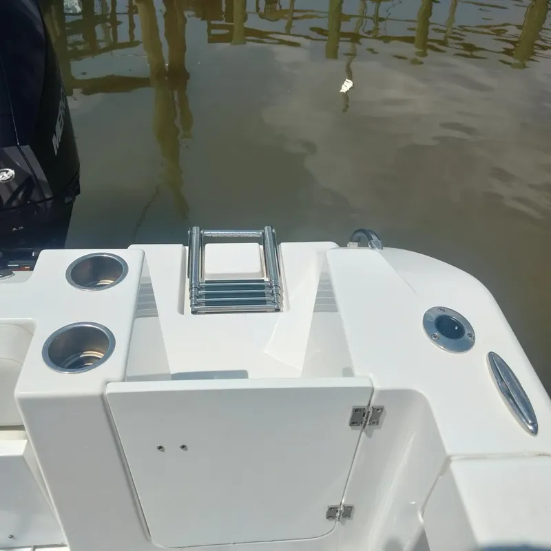 Slide: The Image of 2024 Aquasport 2200 Center Console boat with ladder and cup holders by the water. - 5