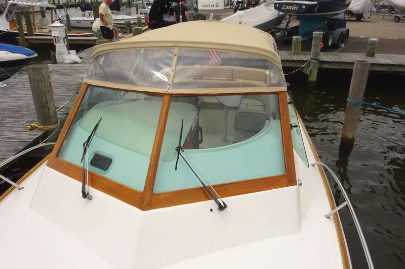 Slide: The Image of 2009 Hunt Yachts Harrier 29 docked, featuring a beige canopy and wooden trim. - 12