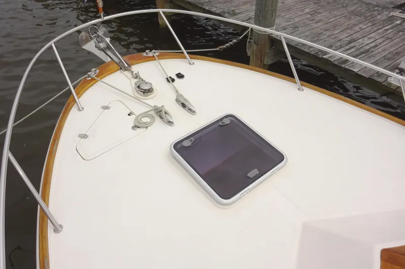 Slide: The Image of 2009 Hunt Yachts Harrier 29 bow with hatch and railing, docked by wooden pier. - 13