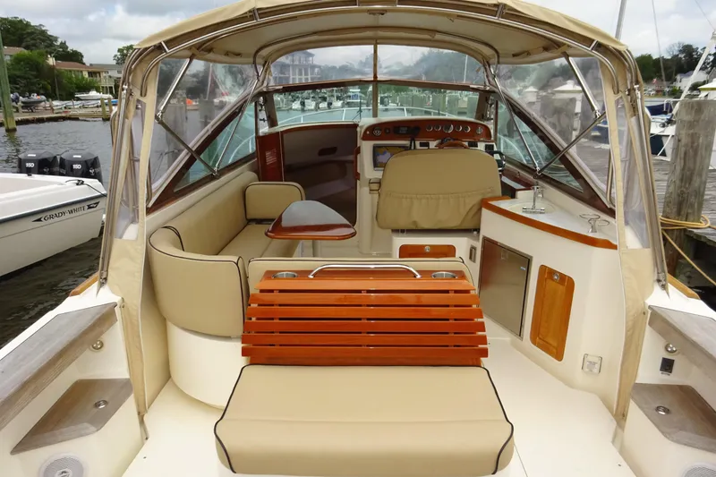 Slide: The Image of 2009 Hunt Yachts Harrier 29 interior with beige seating and wooden accents at a marina. - 15