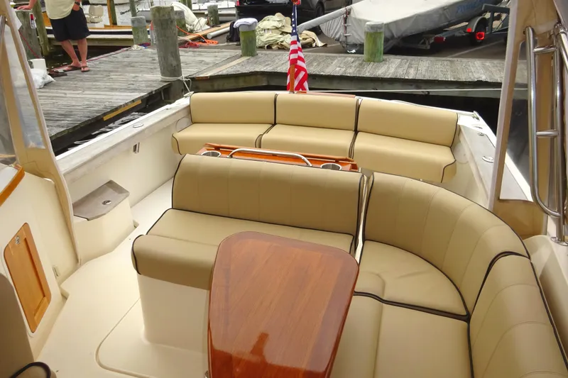 Slide: The Image of 2009 Hunt Yachts Harrier 29 interior with beige seating and wooden table at dock. - 22
