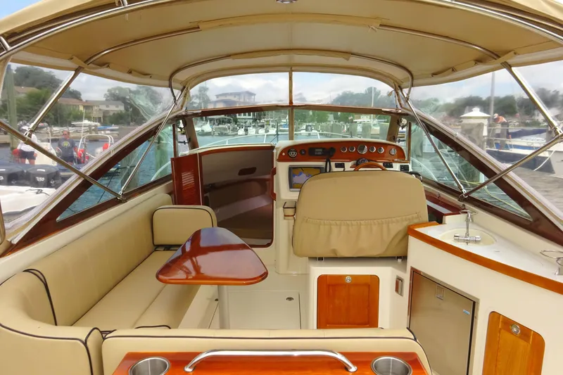 Slide: The Image of 2009 Hunt Yachts Harrier 29 interior with beige seating, wooden accents, and navigational equipment. - 30