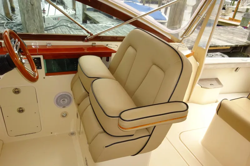Slide: The Image of 2009 Hunt Yachts Harrier 29 interior with beige seating and wooden steering wheel. - 34