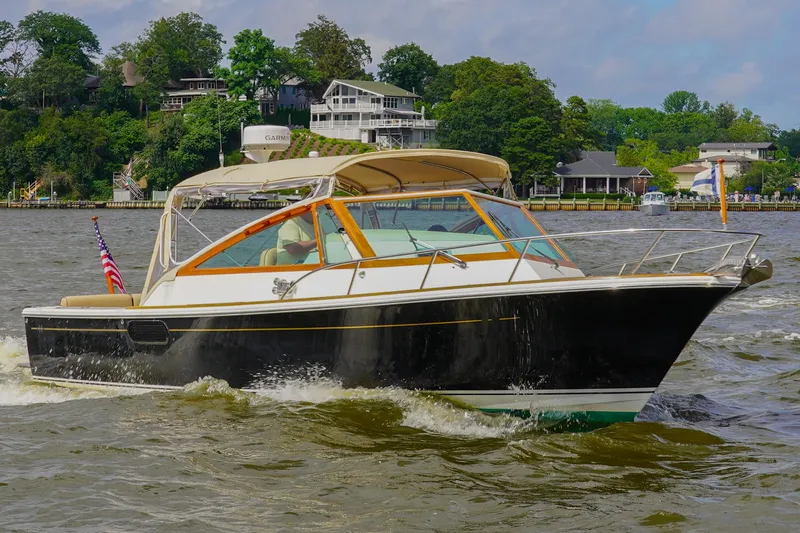 Slide: The Image of 2009 Hunt Yachts Harrier 29 cruising on a scenic river with lush greenery. - 4