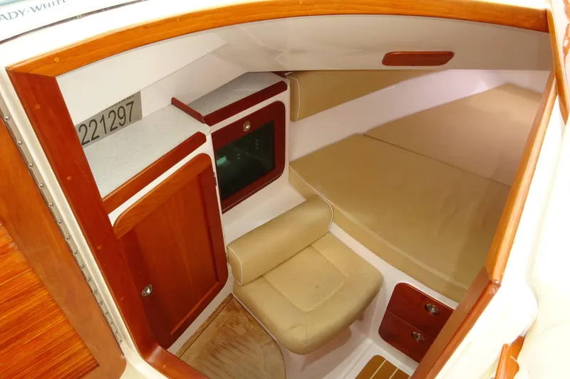 Slide: The Image of 2009 Hunt Yachts Harrier 29 cabin interior with wood accents and beige seating. - 44