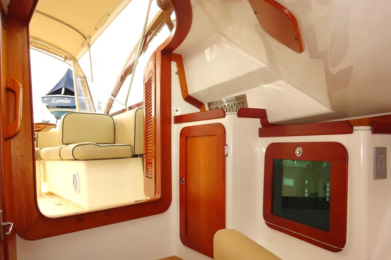 Slide: The Image of Interior of 2009 Hunt Yachts Harrier 29, featuring wood accents and cushioned seating. - 47