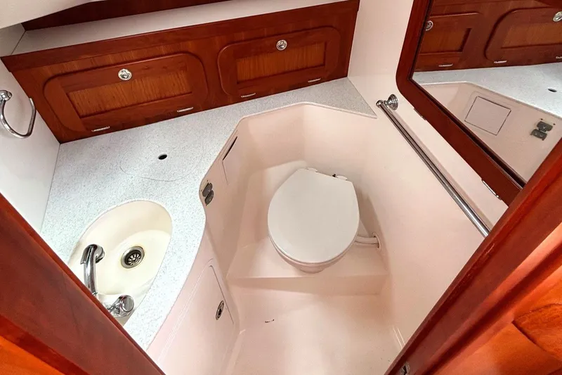 Slide: The Image of 2009 Hunt Yachts Harrier 29 bathroom with sink, toilet, and wooden cabinetry. - 48
