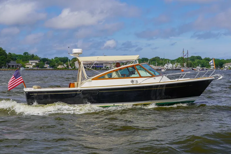 Slide: The Image of 2009 Hunt Yachts Harrier 29 cruising on a scenic waterway with American flag. - 5
