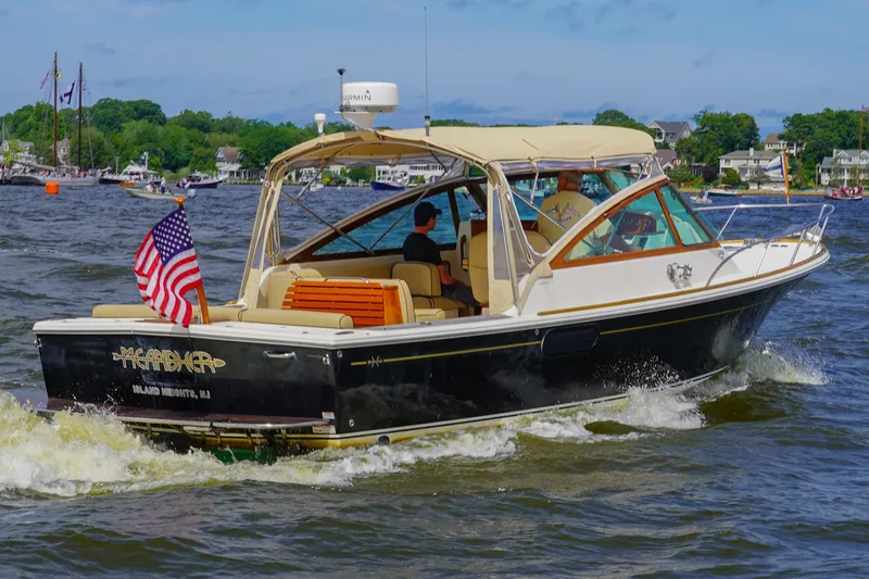 Slide: The Image of 2009 Hunt Yachts Harrier 29 cruising on a scenic waterway with American flag. - 6