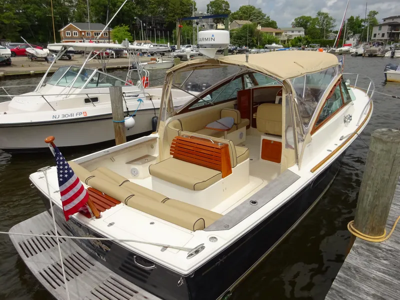 Slide: The Image of 2009 Hunt Yachts Harrier 29 docked, featuring elegant design and American flag. - 7