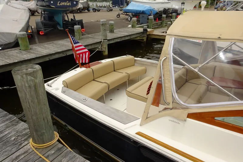 Slide: The Image of 2009 Hunt Yachts Harrier 29 docked, featuring beige seating and American flag. - 9