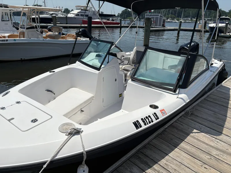 Slide: The Image of 2023 Aquasport 2200 Dual Console boat docked at marina, featuring sleek design and spacious seating. - 1