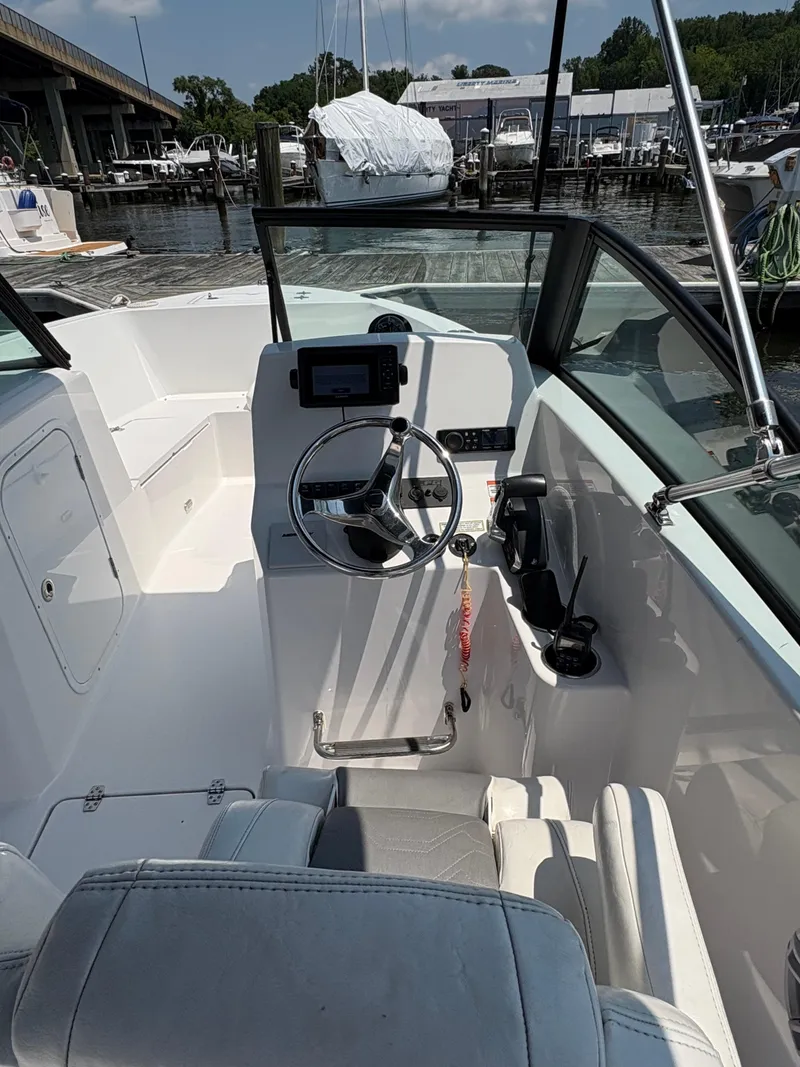 Slide: The Image of 2023 Aquasport 2200 Dual Console boat interior with steering wheel and controls. - 4