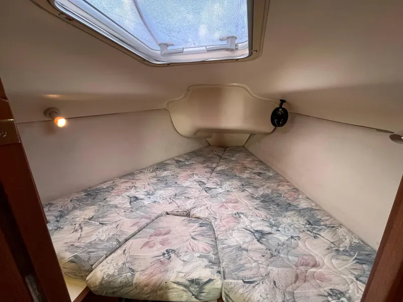 Slide: The Image of Cozy cabin interior of a 2000 Hunter 340 sailboat with floral-patterned bedding. - 24